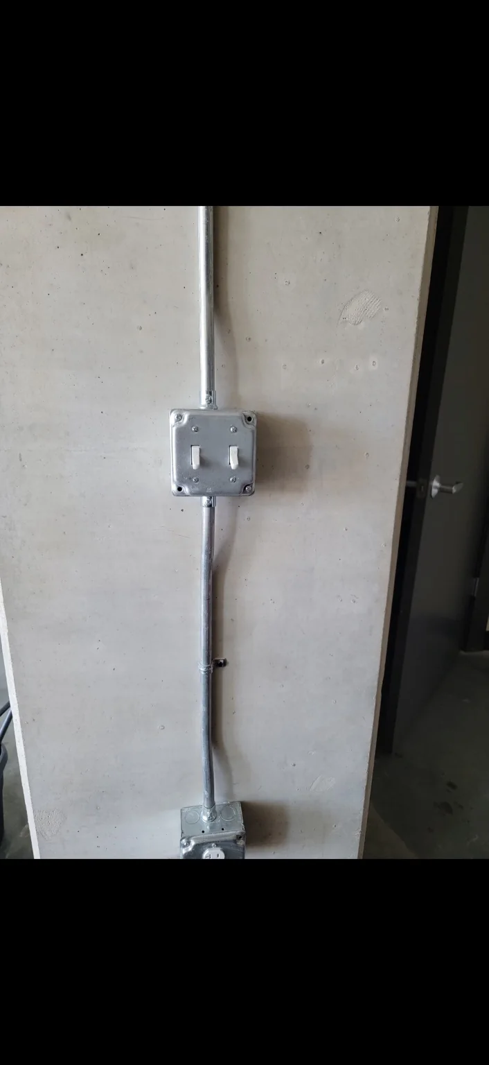 Switches & surface conduit. Wall-mounted switches with a surface conduit route.