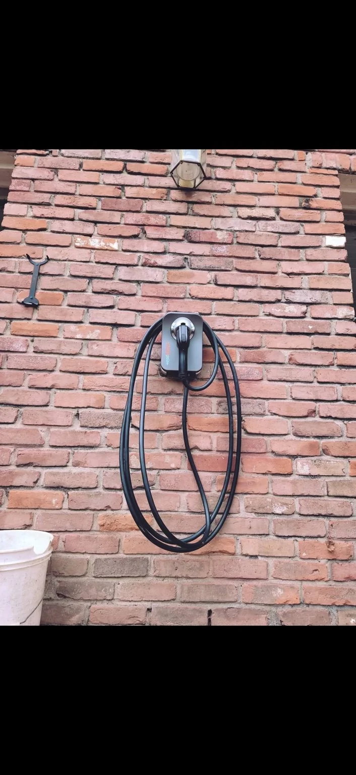 ChargePoint home charger. A wall-mounted charger with its cable stored alongside it.