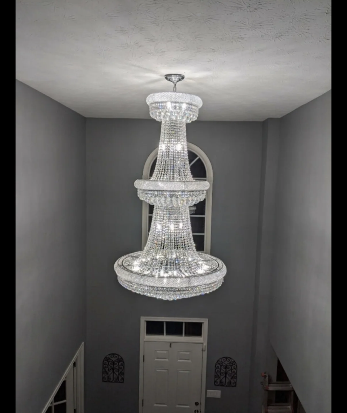 Statement chandelier. A multi-tier chandelier in a tall entryway.